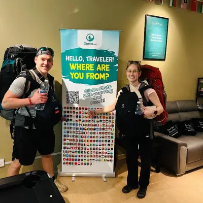a man and a woman standing next to a sign at A3A Oastel CoLiving in Tanah Rata