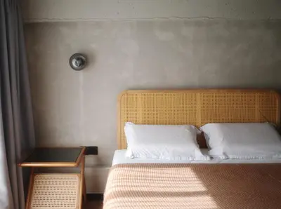 a bedroom with a bed with a yellow headboard and a table at A'moss Farmstay in Cameron Highlands