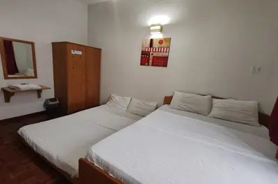 a bedroom with two beds and a mirror at Hotel Check Inn 2 Cameron Highlands in Brinchang