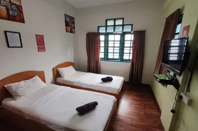 a room with two beds and a television in it at Hotel Check Inn 2 Cameron Highlands in Brinchang