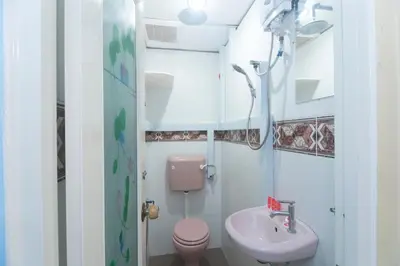 a bathroom with a pink toilet and a sink at Hotel O Rafik Ali Motel in Kepala Batas