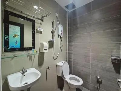 a bathroom with a white toilet and a sink at Anggerik Garden Hotel - AG Hotel in Sitiawan