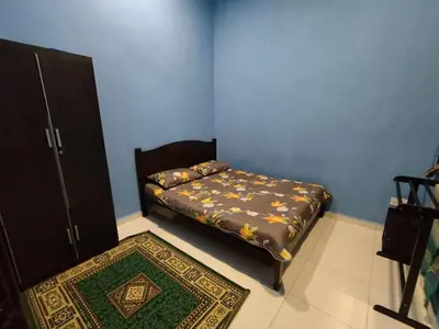 a small bedroom with a bed and a rug at Nurul Homestay in Kepala Batas