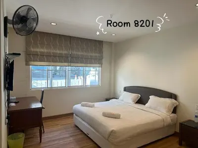 a bedroom with a bed and a desk and a window at Dear Dino House in Tanah Rata