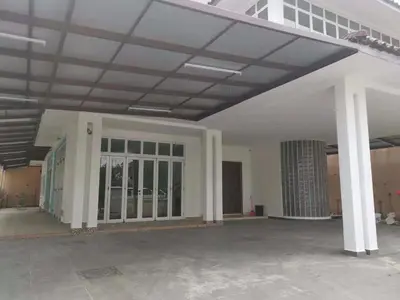 a large white building with a large glass door at Dear Dino House in Tanah Rata