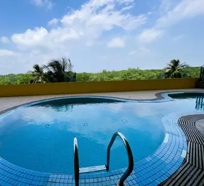 a swimming pool with blue water in a resort at Dindings Pantai Desair Apartment By DPD in Lumut