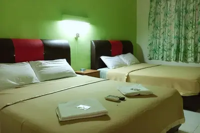 a hotel room with two beds with towels on them at Dindings Pantai Desair Apartment By DPD in Lumut