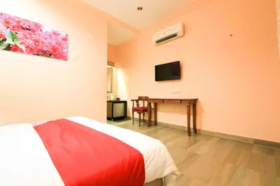 a bedroom with a bed and a desk with a television at Hotel O Ombak Inn Chalet in Pangkor