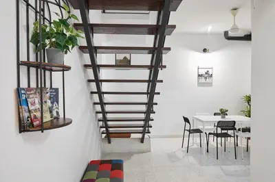 a spiral staircase in a room with a table and chairs at Ipoh Garden Homestay in Ipoh