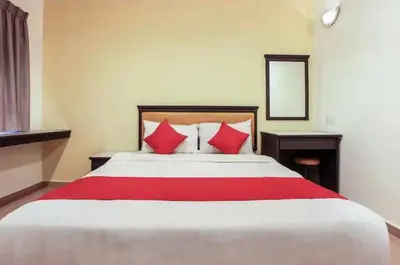 a bedroom with a large bed with red pillows at Hotel Home 88 in Teluk Intan