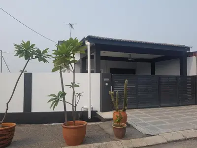 a house with three potted plants in front of it at PINKY VILLA in Ipoh