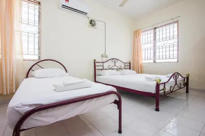 two beds in a room with two windows at Sweet Home With 2 Auto Gates at BM, Penang, M'sia in Bukit Mertajam