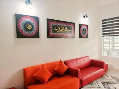 a red couch in a living room with four pictures at Nur Zahra Sungkai Homestay in Sungkai