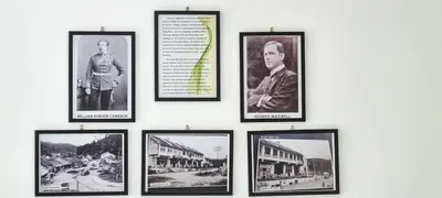 a group of framed photographs on a wall at 80'S PARADISE in Tanah Rata