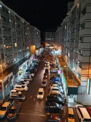 a parking lot full of cars in a city at night at 80'S PARADISE in Tanah Rata