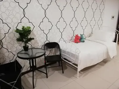 a bedroom with a bed and a table with a chair at Seaview Landmark Studio Homestay at Gurney \u65e0\u654c\u6d77\u666f\u5957\u623f in Tanjong Tokong