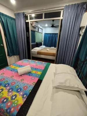 a bedroom with a bed and a mirror at MyDusun Chalet, Taiping, Perak, Malaysia in Taiping