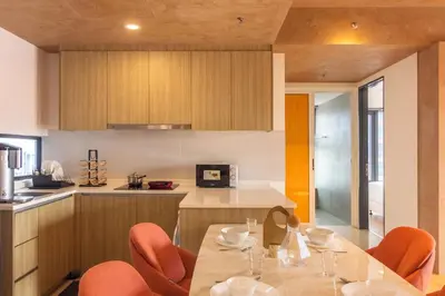 a kitchen with a table and orange chairs in a kitchen at Georgetown Tropicana 218 by Airlevate Suites in George Town