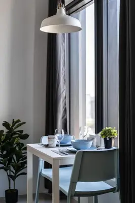 a dining room table with two chairs and a light fixture at De Pastel Studio - SeaView at 218 Tropicana NEAR Komtar Food Heaven with Netflix & TV Box in George Town
