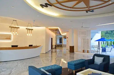 a lobby with blue furniture and a large ceiling at AVI Pangkor Beach Resort in Pangkor