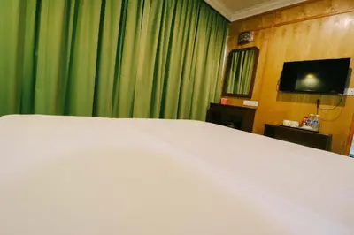 a bedroom with a large white bed and a television at Hotel Rose Crest Hill, Cameron Highlands in Cameron Highlands