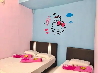 two beds in a room with a hello kitty wall sticker at Kampar Sakura 2 Landed in Kampar
