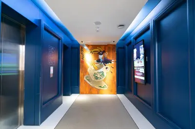 a hallway with blue walls and a mural of a coffee cup at The Upper House, Batu Kawan in Batu Kawan