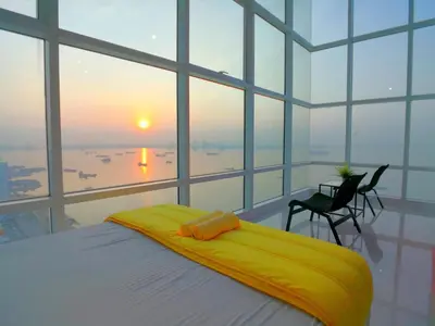 a bedroom with a bed with a view of the ocean at Maritime Suites by Comfy in George Town
