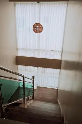 a staircase with a window and a chandelier in a building at OK FAMILY VILLA in Ipoh