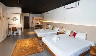 a room with two beds and a table and a chair at Abu Siti George Town in George Town