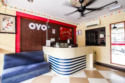 a restaurant with a counter and blue chairs at OYO 89549 Casavilla Hotel (city Centre) Taiping in Taiping