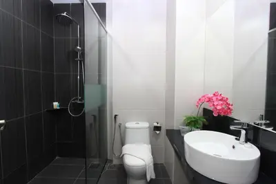 a bathroom with a shower and a toilet and a sink at Ipoh Downtown Hotel in Ipoh