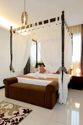 a bedroom with a canopy bed with white curtains at Ipoh Downtown Hotel in Ipoh