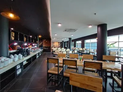 a dining room with wooden tables and chairs in a restaurant at Raia Inn Penang in Bayan Lepas