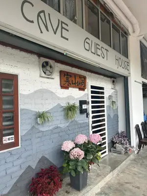 a cure guest house with flowers in front of it at The Cave - Adults Only in Tanah Rata