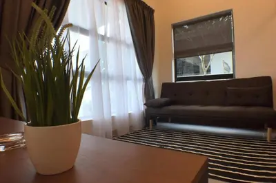 a living room with a couch and a table with a plant at Mary's Residence Ipoh in Ipoh