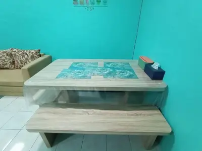 a coffee table in a room with a blue wall at The Handz House II with WIFI - For family or same gender only in Kepala Batas