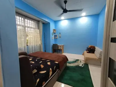 a bedroom with blue walls and a bed and a couch at The Handz House II with WIFI - For family or same gender only in Kepala Batas
