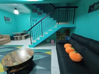 a living room with a couch with oranges on it at The Handz House II with WIFI - For family or same gender only in Kepala Batas