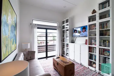 a living room with a couch and book shelves at Jomstay Mayhaven Villa (Ipoh) in Ipoh