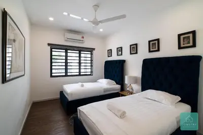a bedroom with two beds and a blue headboard at Jomstay Mayhaven Villa (Ipoh) in Ipoh