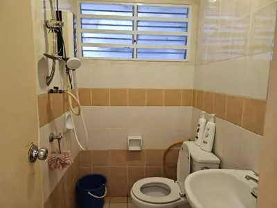 a bathroom with a toilet and a sink and a window at Jeffrey Homestay Ipoh R at Lost World of Tambun in Tambun