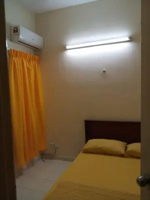 a bedroom with a bed and a yellow curtain at Jeffrey Homestay Ipoh R at Lost World of Tambun in Tambun