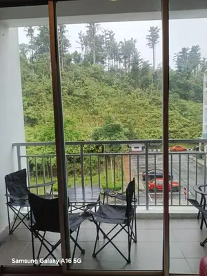 a balcony with chairs and a view of a mountain at Galina Somersquare Goldenhills Aprt Pasar Malam Cameron Highlands in Brinchang