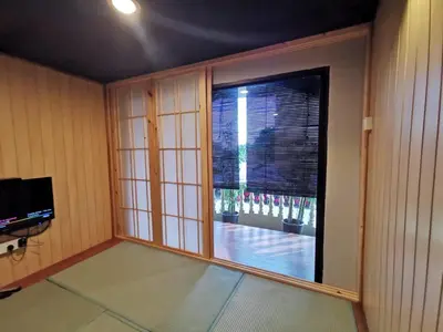 a room with a large window and a television at Tatami D'Tepi Laut - PANGKOR ISLAND in Pangkor