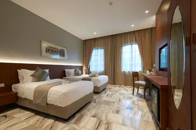 a hotel room with two beds and a television at Macalister Terraces Hotel in George Town