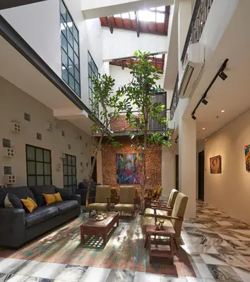 a living room with couches and tables in a building at Macalister Terraces Hotel in George Town