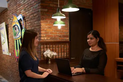 two women standing at a table with a laptop at Macalister Terraces Hotel in George Town