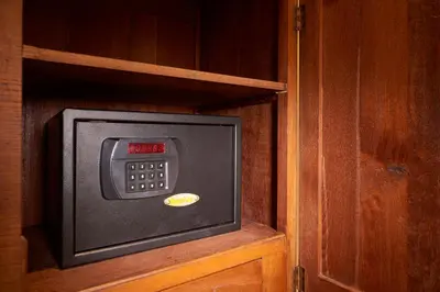 a small television in a cabinet with a clock at Macalister Terraces Hotel in George Town