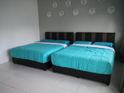 two beds sitting next to each other in a bedroom at My Homestay N18 (14 pax) @ Golden Hills Night Market in Brinchang